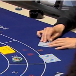 Un joueur plie la carte de baccarat dans un casino de Macao Un joueur plie la carte de baccarat dans un casino de Macao